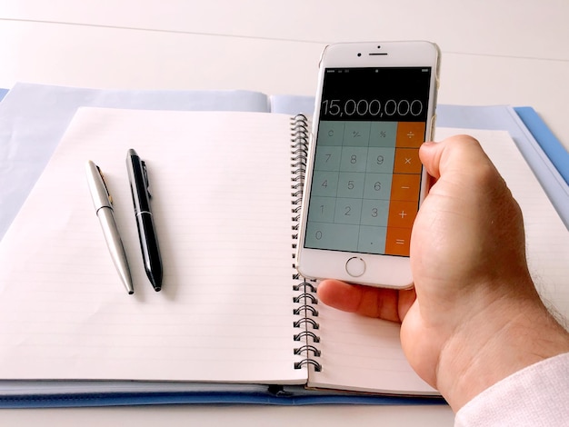 A person is using a budgeting app on their smartphone, displaying categories like 