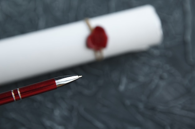 A close-up of an acceptance letter from a prestigious university, resting on top of a stack of textbooks. The lighting is soft and warm, highlighting the embossed university seal and the recipient's name. A pen and a pair of glasses are casually placed beside the letter, suggesting a moment of thoughtful reflection.