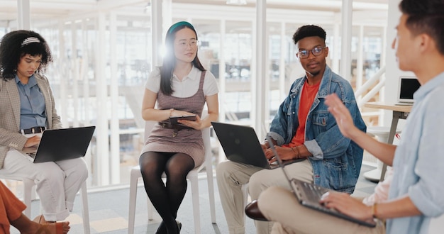 A diverse group of professionals attending a workshop, actively participating in hands-on activities, with laptops and notebooks spread out on the tables. The atmosphere is collaborative and engaging, reflecting the practical nature of micro-credential programs.