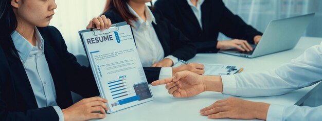 A human resources professional reviewing a resume, highlighting specific skills and certifications that align with the job requirements. The office setting is modern and professional, emphasizing the importance of talent acquisition and development.