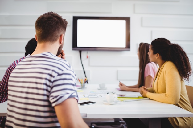 A college student confidently presenting a project to a team of professionals in a corporate boardroom; the setting symbolizes the practical application of academic knowledge through internship opportunities.