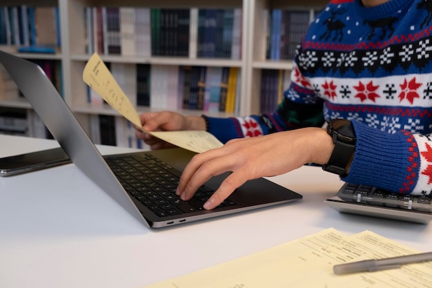 A close-up of a college student reviewing notes with a study group in a brightly lit library, surrounded by books and laptops, all focused on the material.