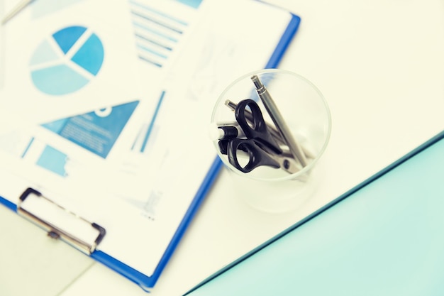 A close-up of financial statements with a magnifying glass over them, highlighting key figures and ratios. A pen and notepad lie nearby, suggesting the act of analysis and note-taking.