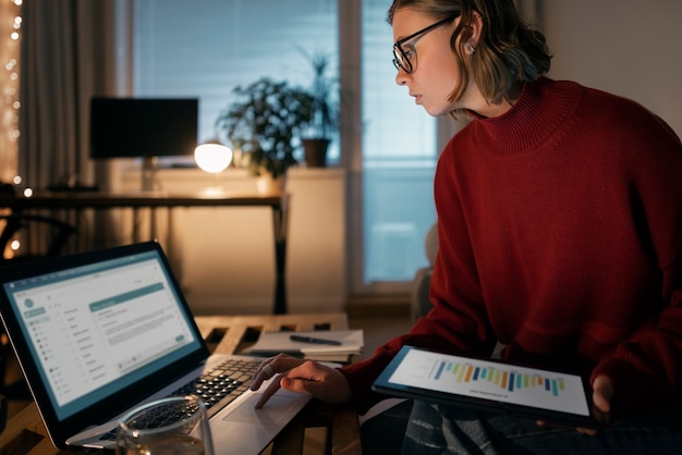 A person sitting at a desk, reviewing paperwork and a laptop displaying various investment charts and data, with a financial calculator nearby.