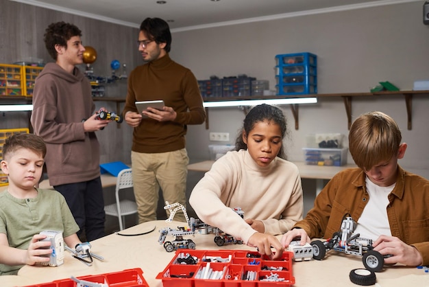 High school students working collaboratively on a robotics project, with a teacher supervising. The scene highlights hands-on learning and teamwork skills.
