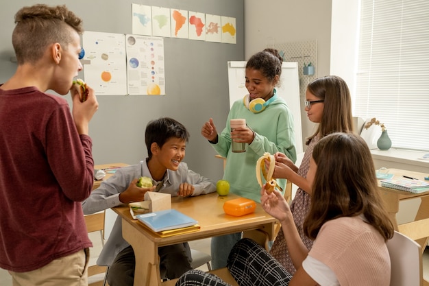 A classroom setting with diverse students engaged in a learning activity, with a teacher guiding them. The atmosphere is positive and inclusive.