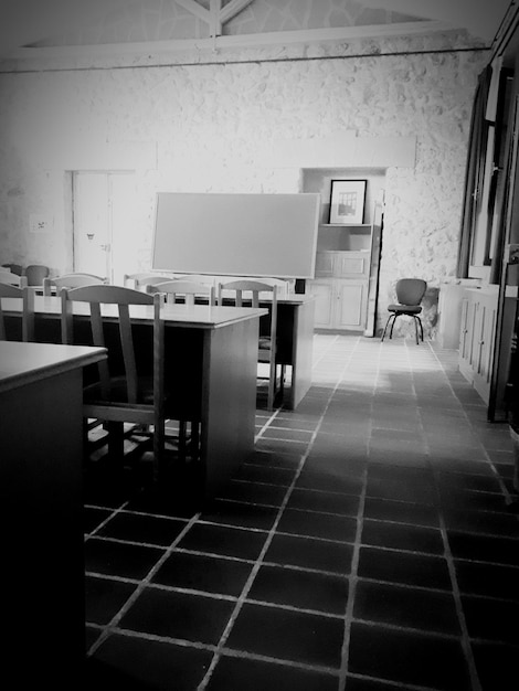 A split image showing a well-equipped private school classroom on one side and an overcrowded, under-resourced public school classroom on the other, highlighting the disparities in educational opportunities that voucher programs aim to address.