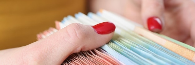 A close-up shot of various loan documents spread out on a table, with hands holding a calculator and a pen, focusing on interest rate sections of the documents. The scene uses a shallow depth of field to emphasize the importance of the interest rates.