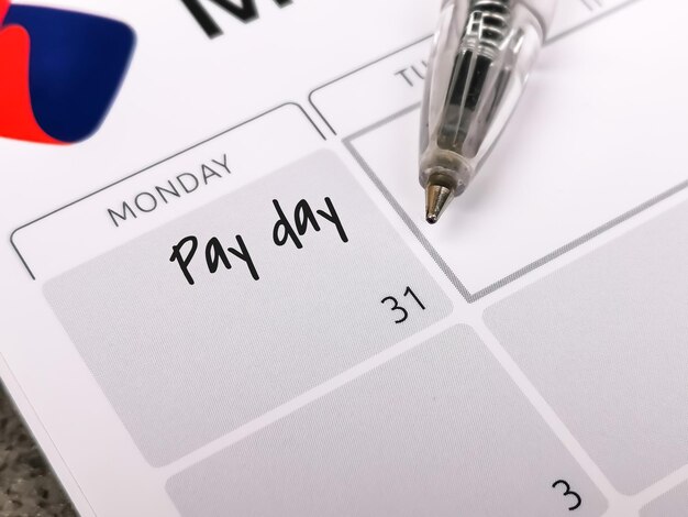 A close-up shot of a calendar with several dates marked to indicate bill payment reminders, emphasizing the importance of on-time payments.