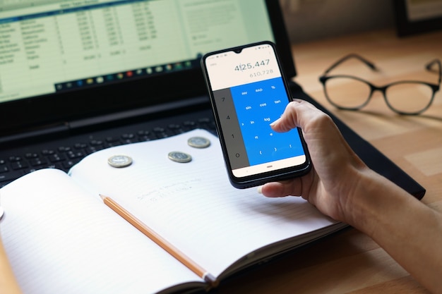 A hand holding a smartphone displaying a budgeting app with categorized expenses for needs, wants, and savings, showing a clear allocation of income.