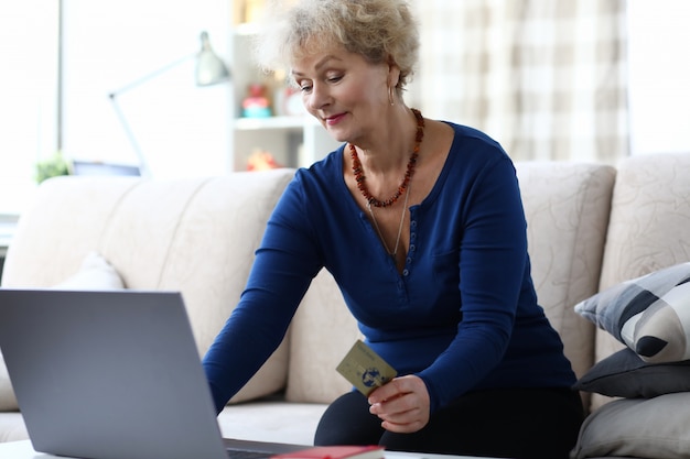 A person happily using a laptop to manage their retirement account, showing the convenience of online investing.