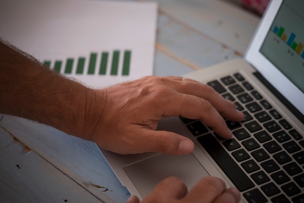 A close-up shot of a person's hands using a laptop, with a credit report displayed on the screen, highlighting the importance of regular credit monitoring for fraud detection.