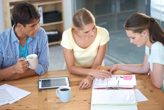 A close-up shot of a family sitting at a table, reviewing financial documents and using a laptop. They are smiling and engaged, illustrating financial planning and family involvement in saving for college.