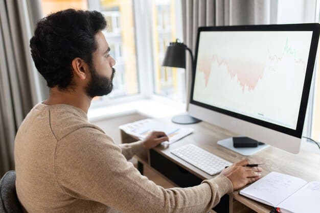 A person sitting at a desk looking at charts and graphs on a computer screen, representing research and analysis of REIT investments.